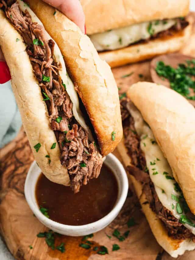 French Dip Sandwich dipping in au jus.