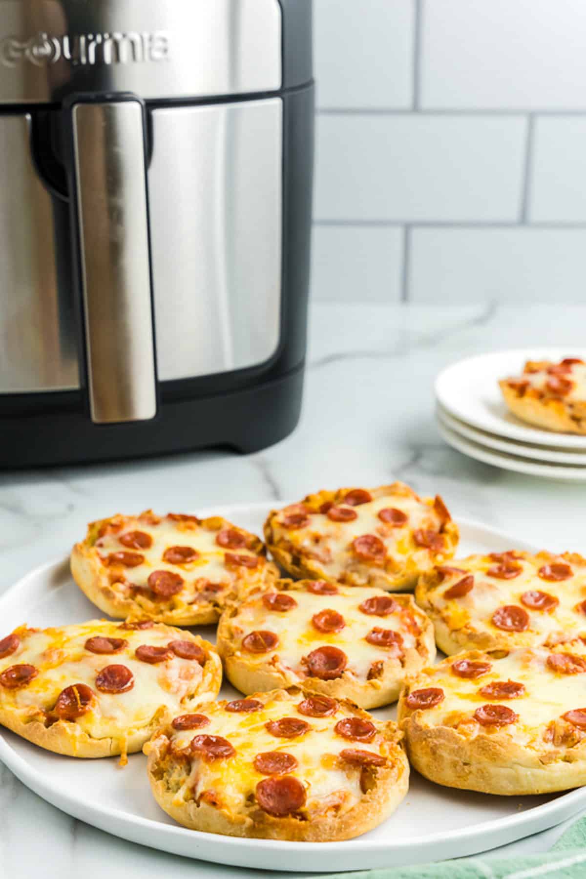 Plate with English Muffin Pizzas with Air Fryer in background