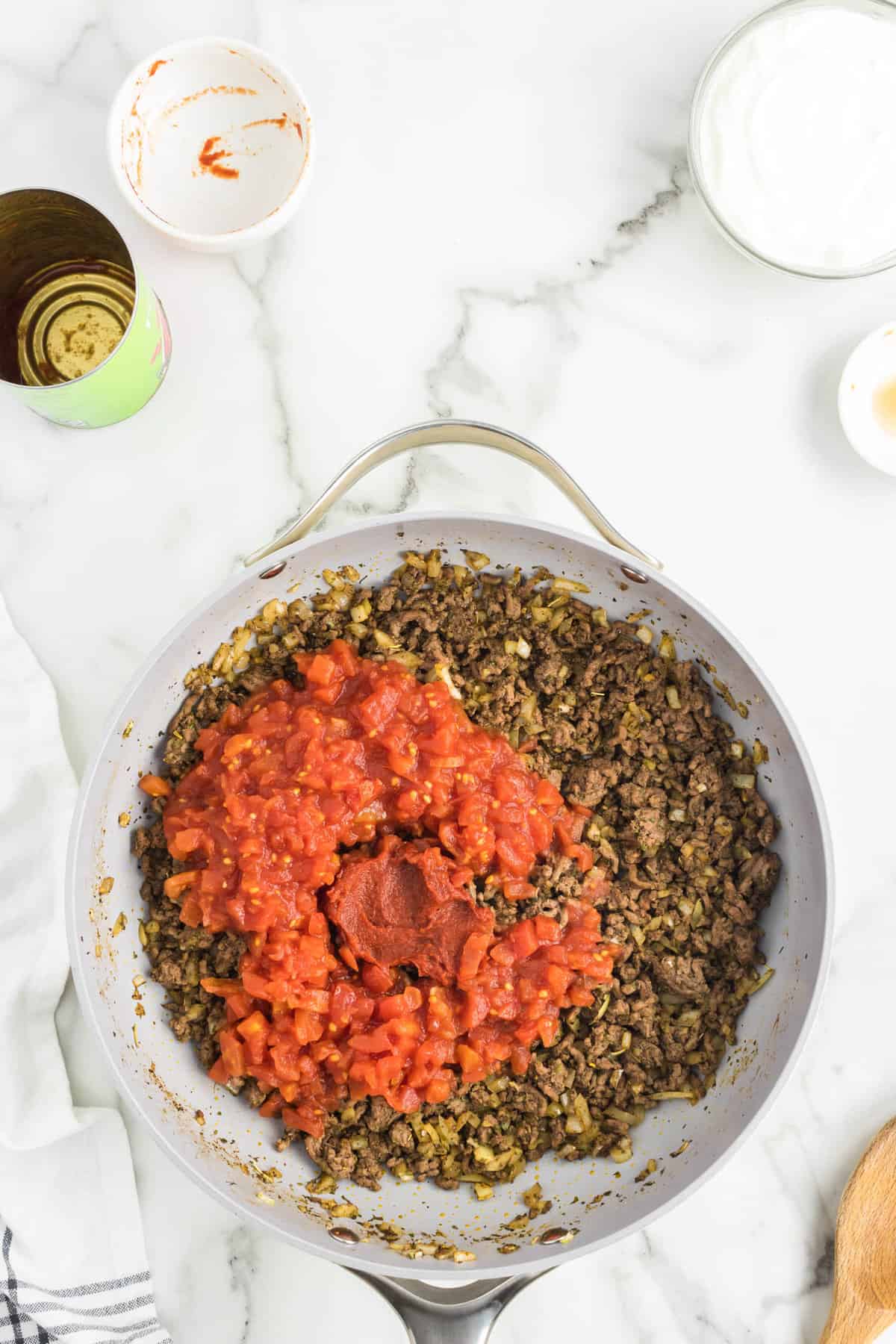 Adding tomatos and paste to stovetop mixture for Cheeseburger Casserole