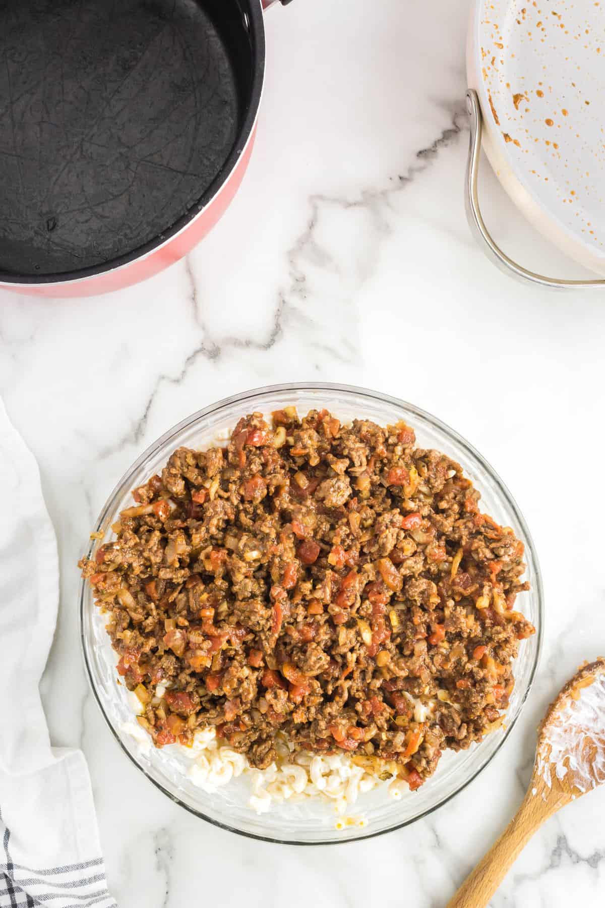 Mixing Cheeseburger Casserole mixture with elbow noodles in mixing bowl