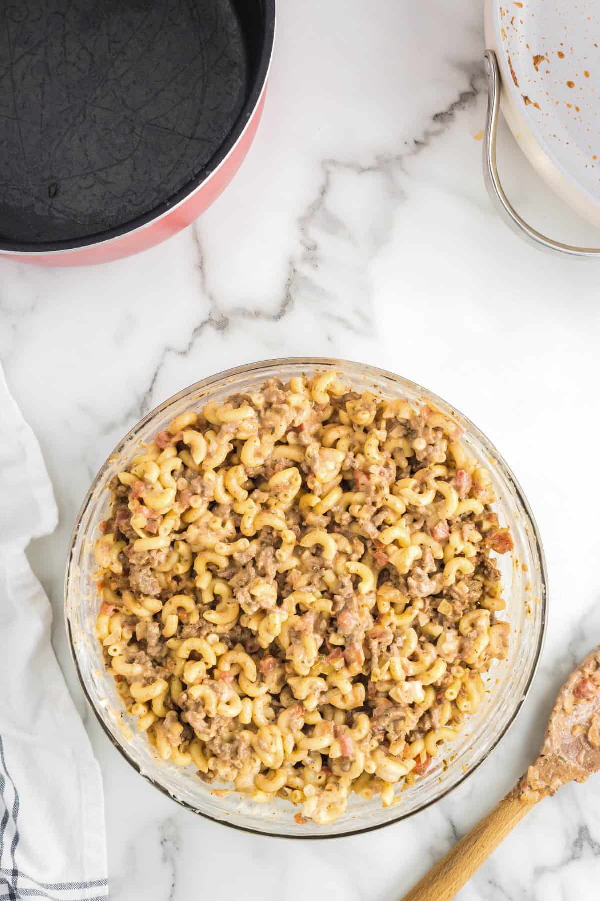 Noodle and seasoned cheeseburger mixture combined in mixing bowl