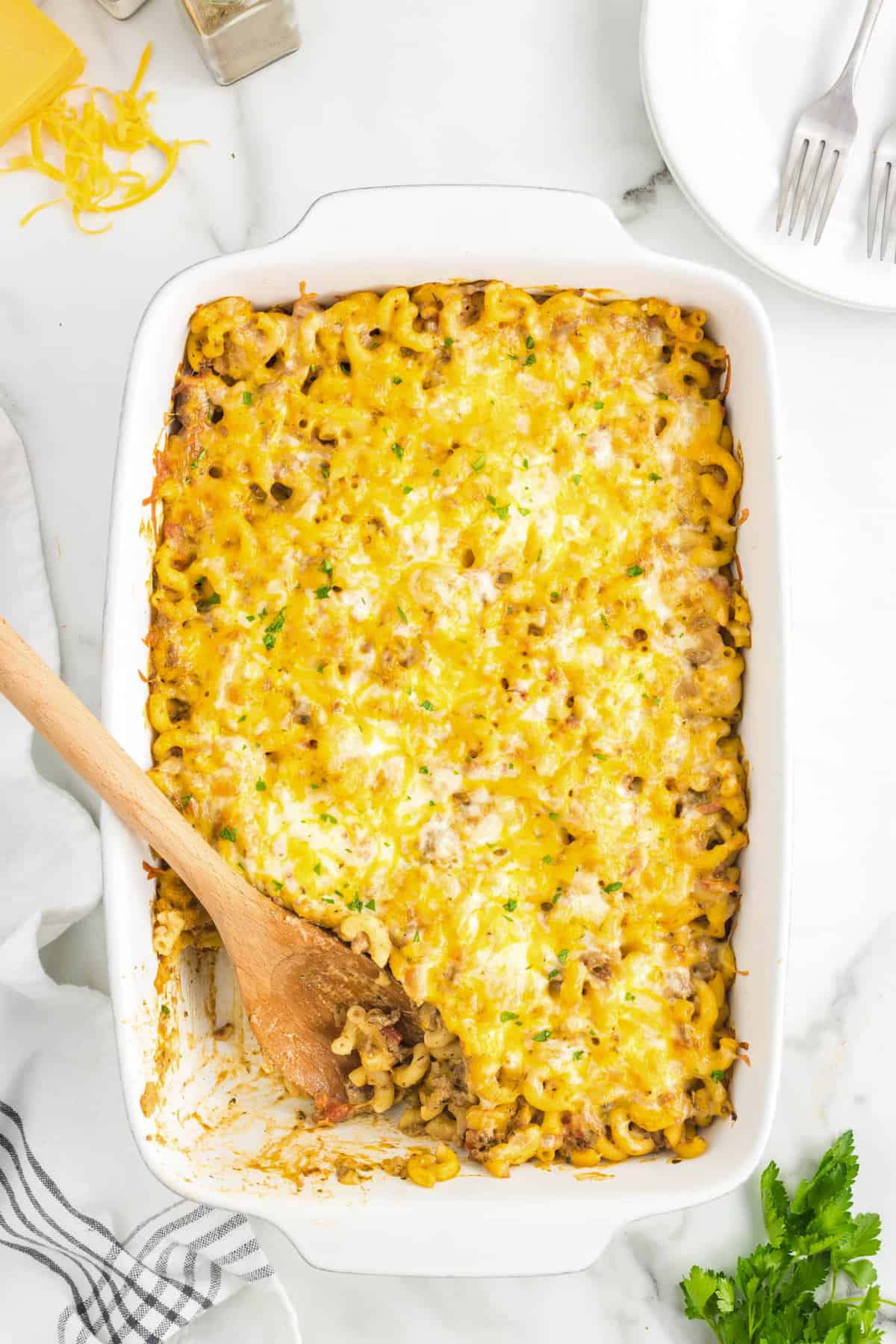 Using wooden spoon to scoop out the first helping of Cheeseburger Casserole