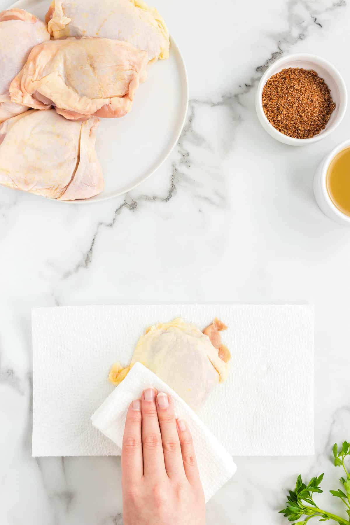 Patting bone-in skin-on chicken thigh with paper towl for Slow Cooker Chicken Thighs