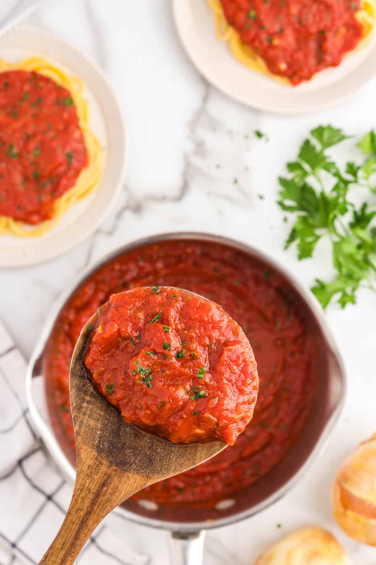 Spooning Best Marinara Sauce Recipe from stovetop pot 