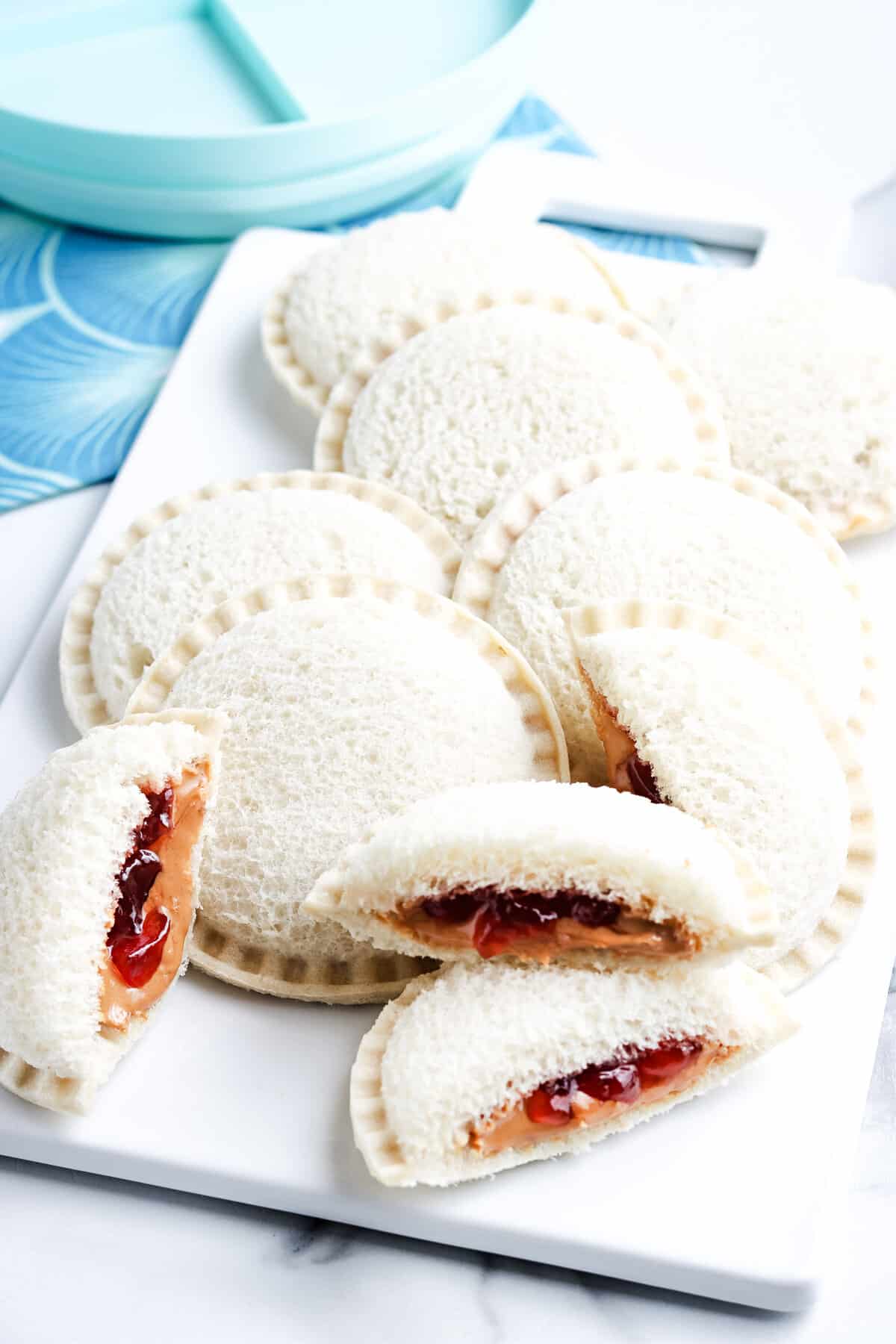 Homemade Uncrustables cut and on a white plate