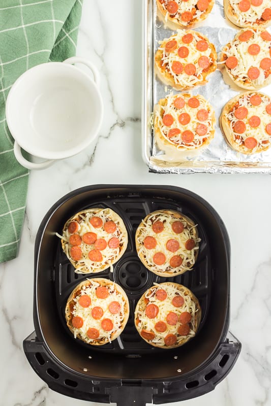 Once English muffins have cooked for 3 minutes, add Pizza Sauce, Mozzarella cheese and Pepperonis to the top.