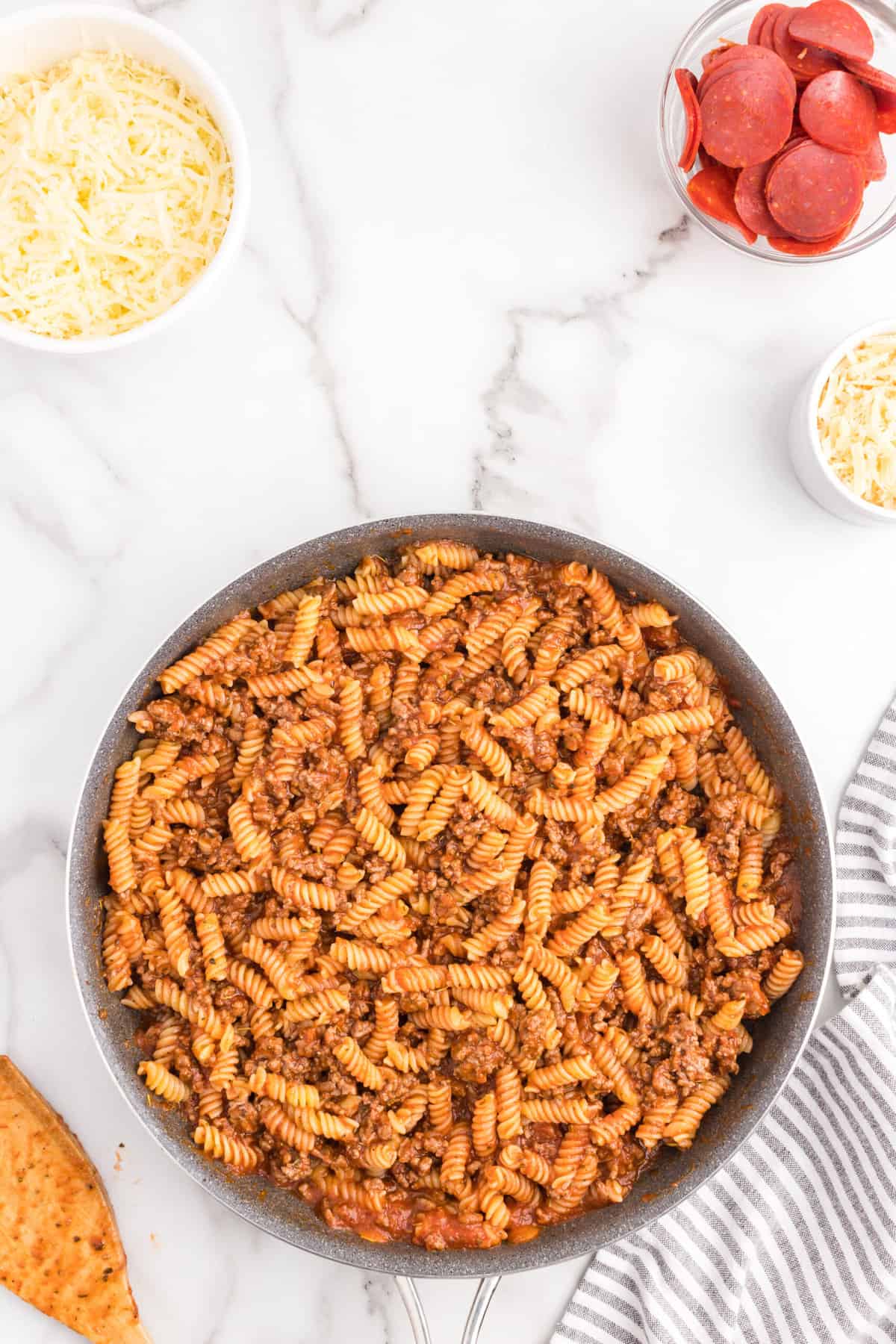 Combined casserole ingredients in stovetop skillet for pepperoni pizza casserole