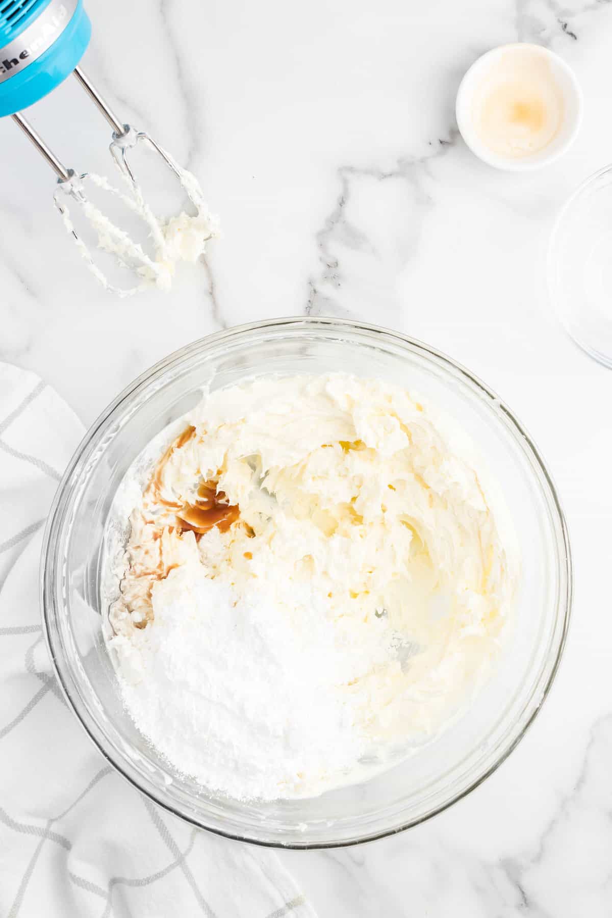 Adding powdered sugar and vanilla to cream cheese and sour cream mixture for No Bake Blueberry Cheesecake