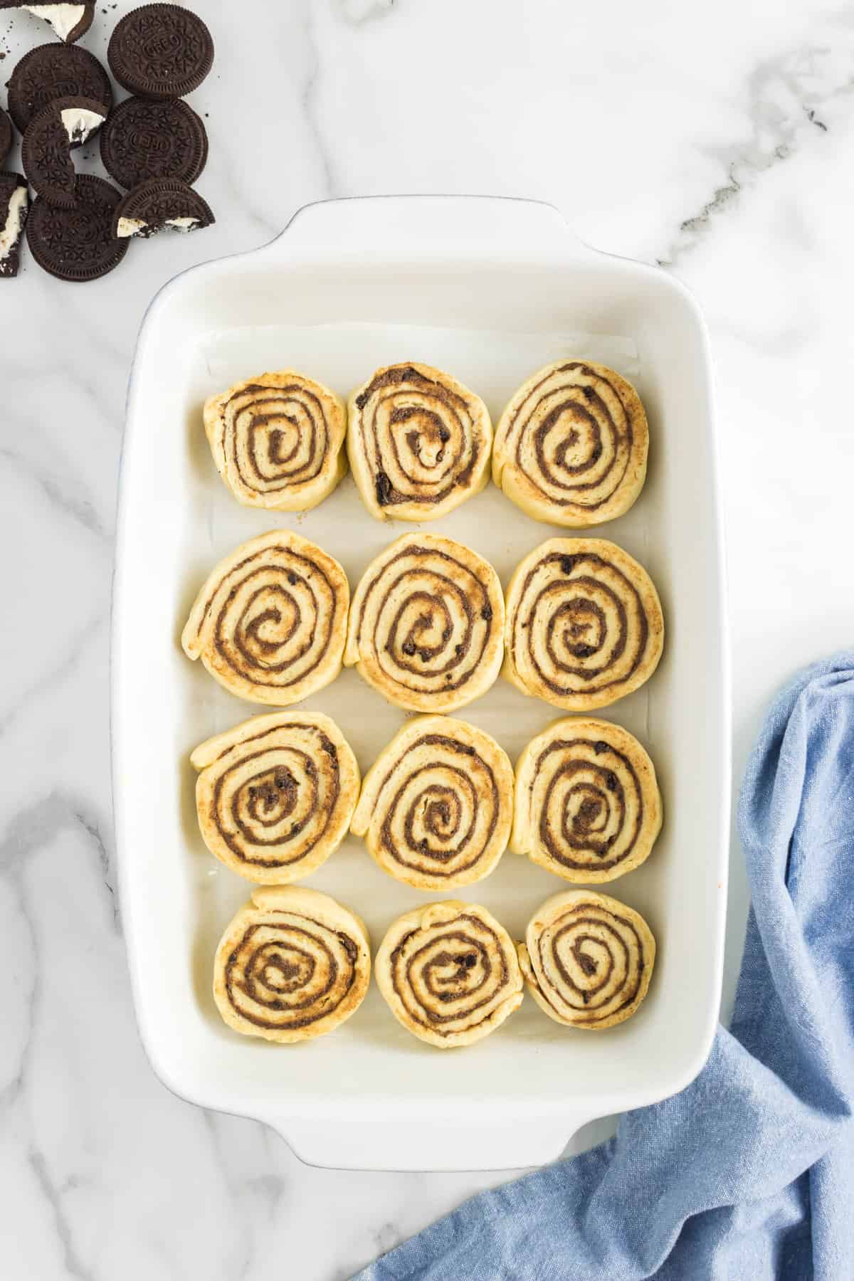 Placing sliced rolls in 9x13 baking pan for Oreo Cinnamon Rolls