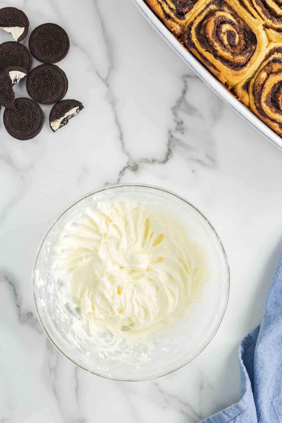 Whipping cheese frosting in small mixing bowl for Oreo Cinnamon Rolls