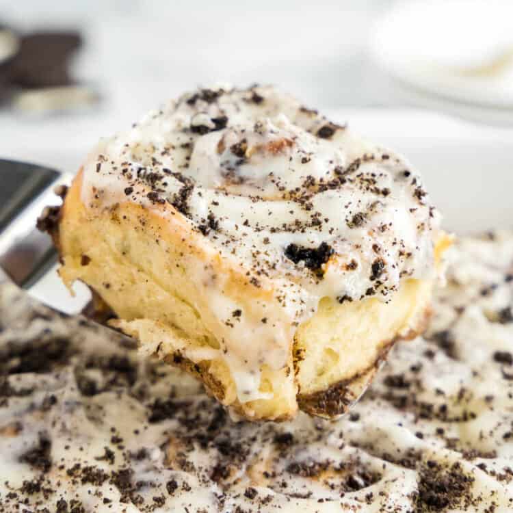 Scooping Oreo Cinnamon Rolls out of pan with spatula