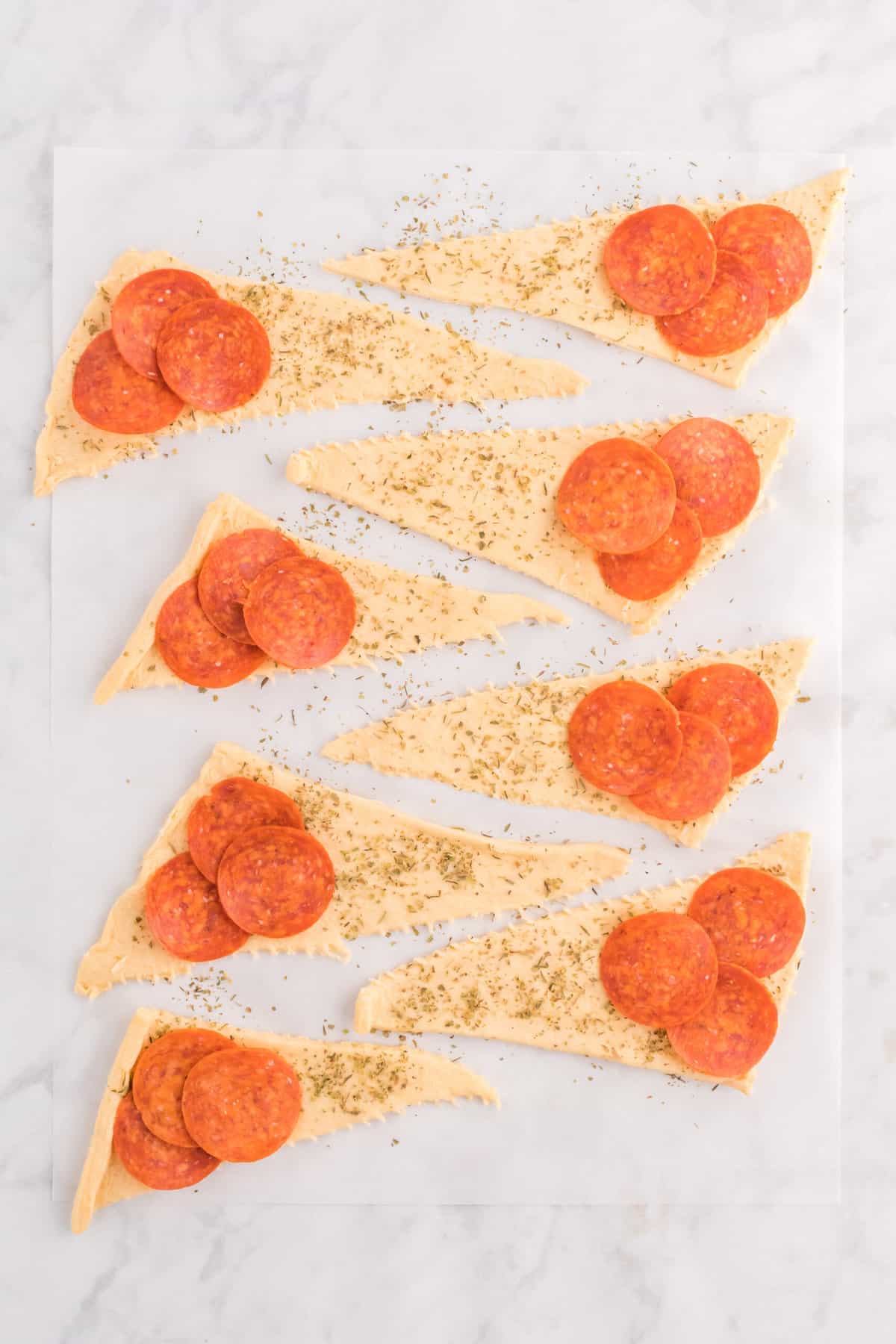 on the Widest part of the Crescent Rolls add three pieces of pepperoni.