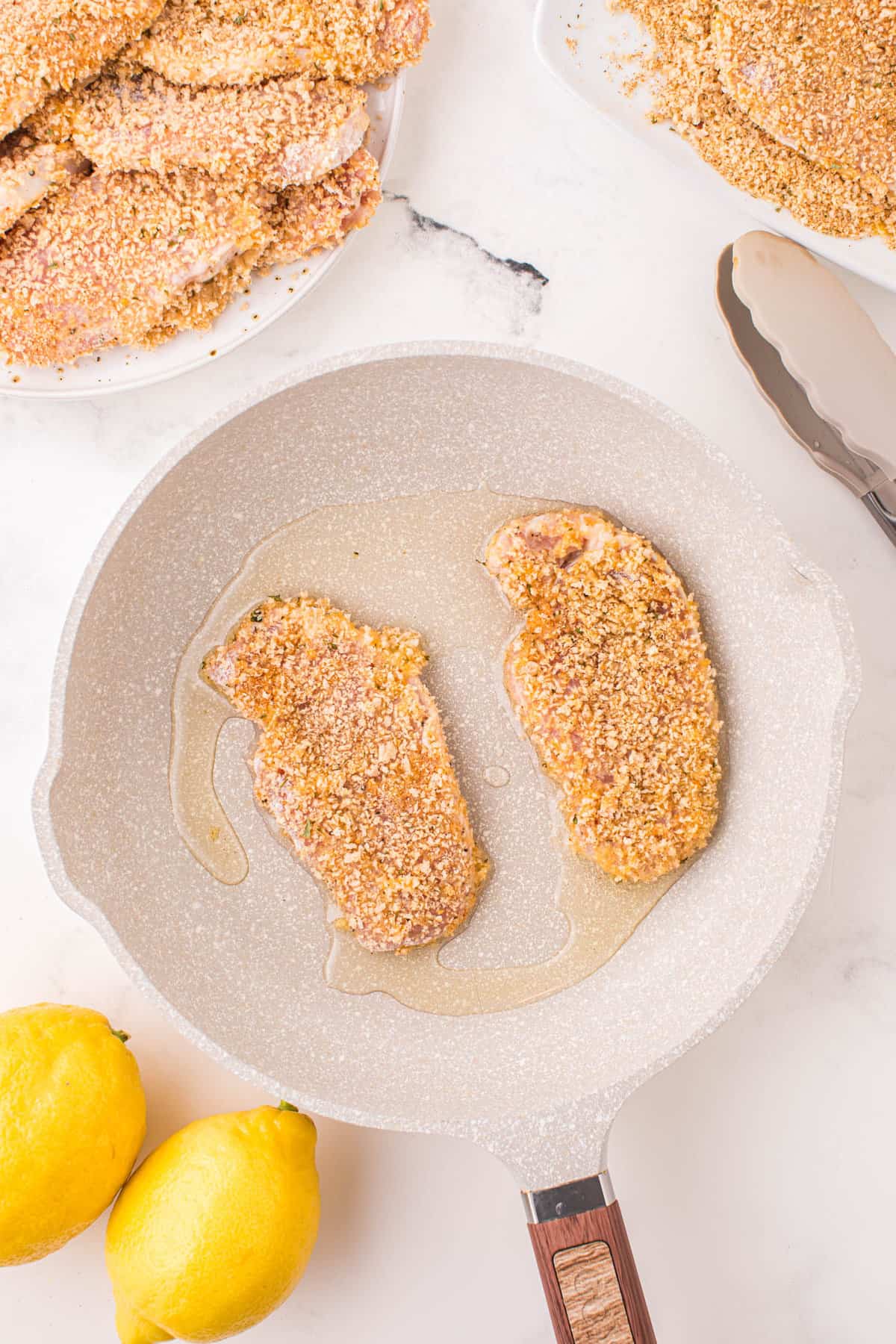 Seasoned and Coated Pork Cooking in Pan for German Pork Schnitzel Recipe