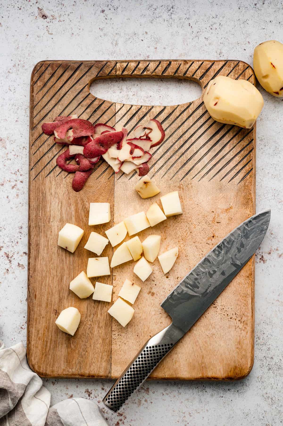 Peeling and dicing potatoes on cutting board for Potato Salad recipe