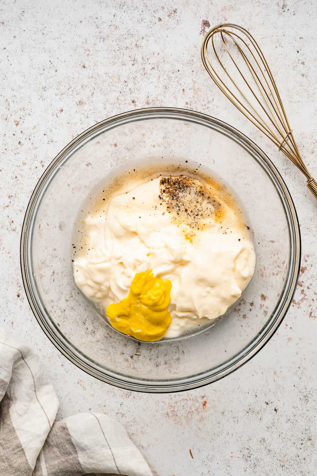 Whisking dressings and seasonings in bowl for easy potato salad