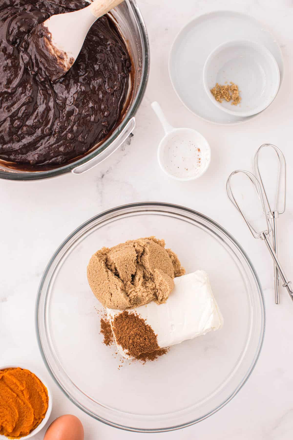 Creaming together brown sugar, cream cheese, and pumpkin spice in bowl for Pumpkin Brownies Recipe