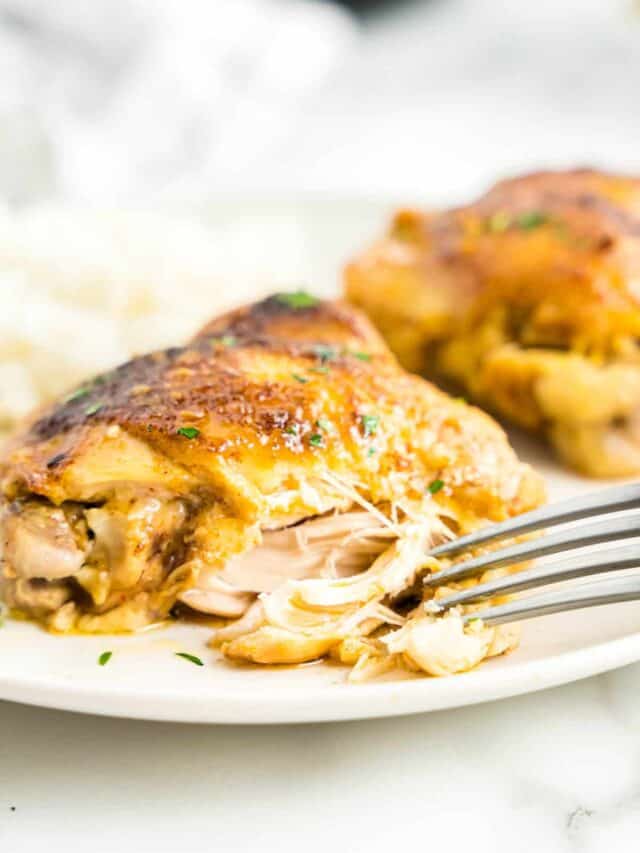 Slow Cooker Chicken Thighs on Plate with Fork Breaking Apart Thigh