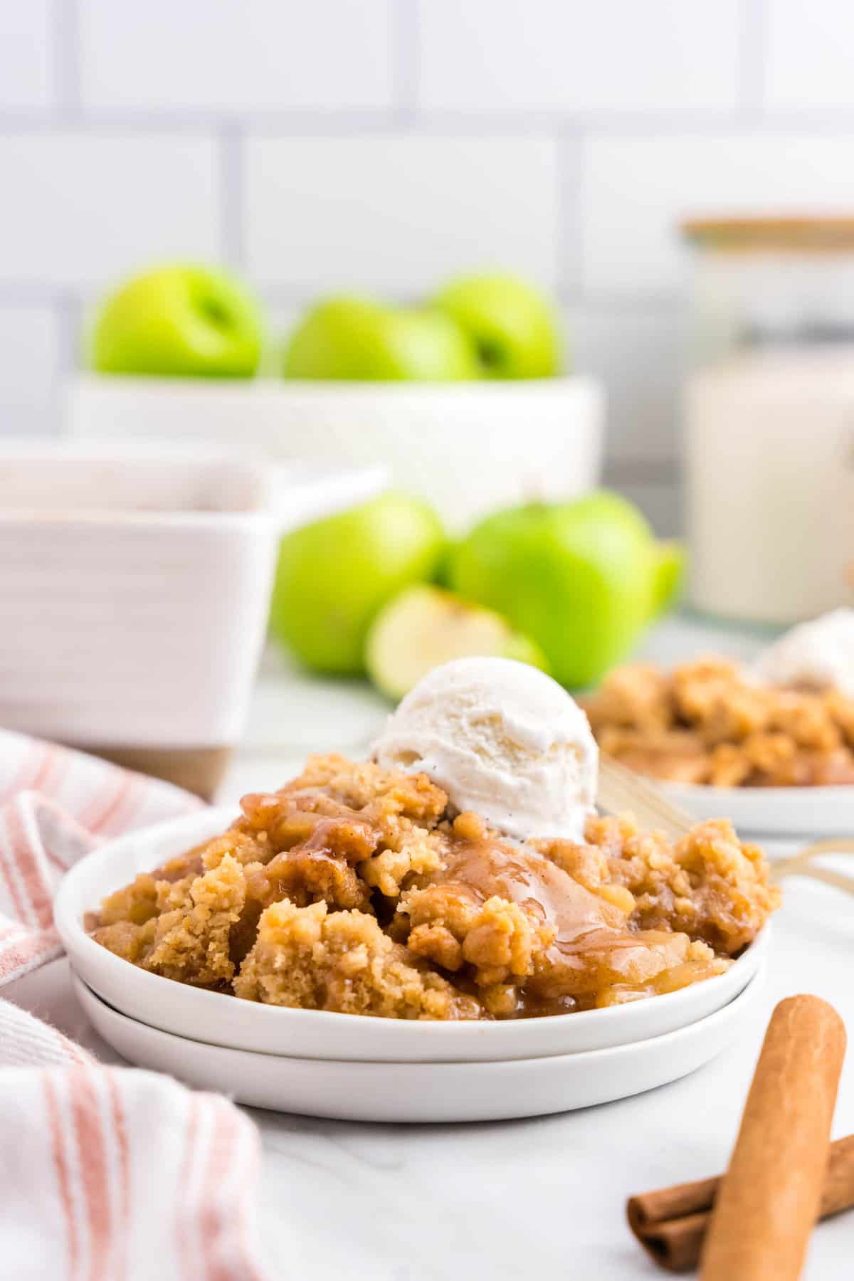 Apple Crumble on plate topped with vanilla ice cream and drizzled with caramel