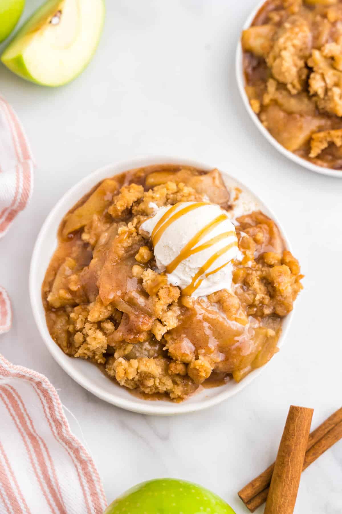 Apple Crumble on Plate topped with vanilla ice cream and drizzled carmel