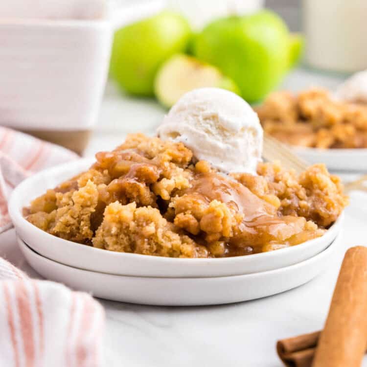 Apple Crumble on plate topped with vanilla ice cream and drizzled carmel