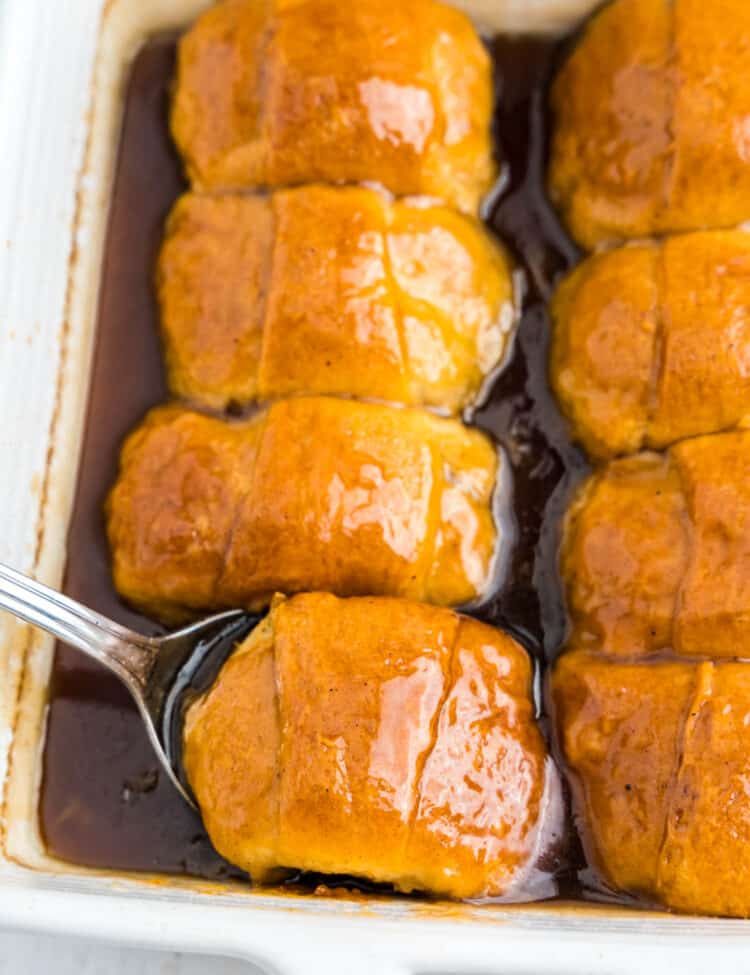 Spoon scooping apple dumpling out of pan