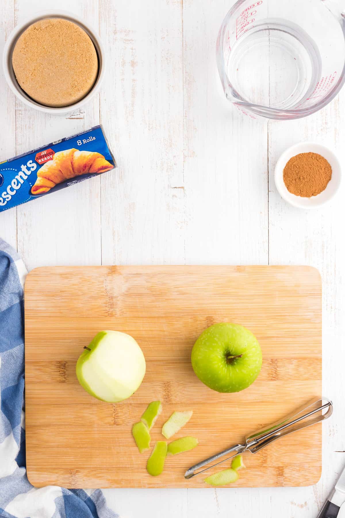 Peeling granny smith apples on cutting board for Crescent Roll Apple Dumplings recipe