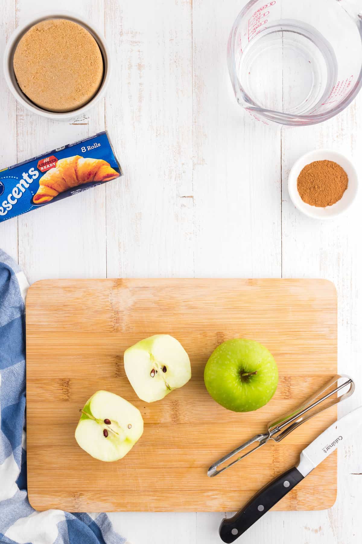 Halving granny smith apples on cutting board for Crescent Roll Apple Dumplings recipe