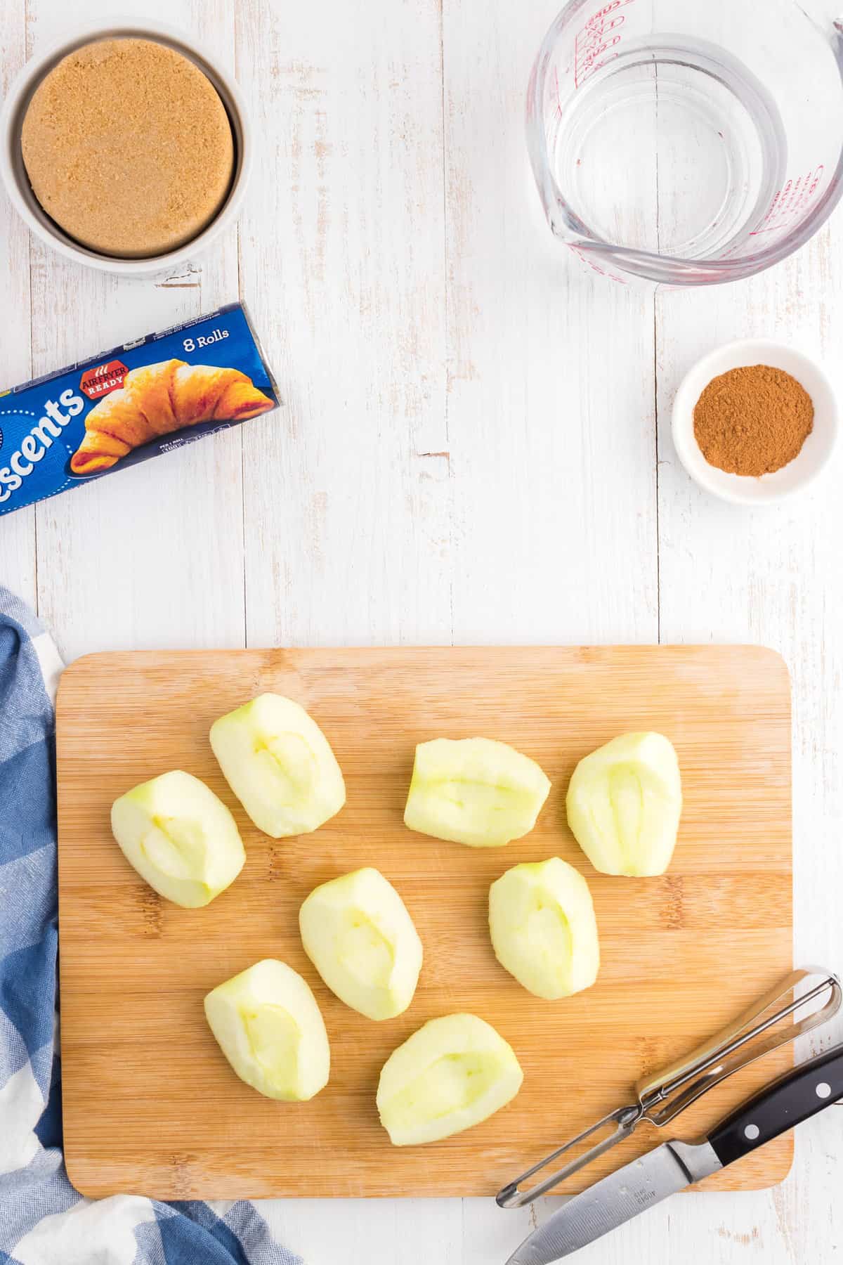 Peeled and cut granny smith apples on cutting board for Crescent Roll Apple Dumplings recipe