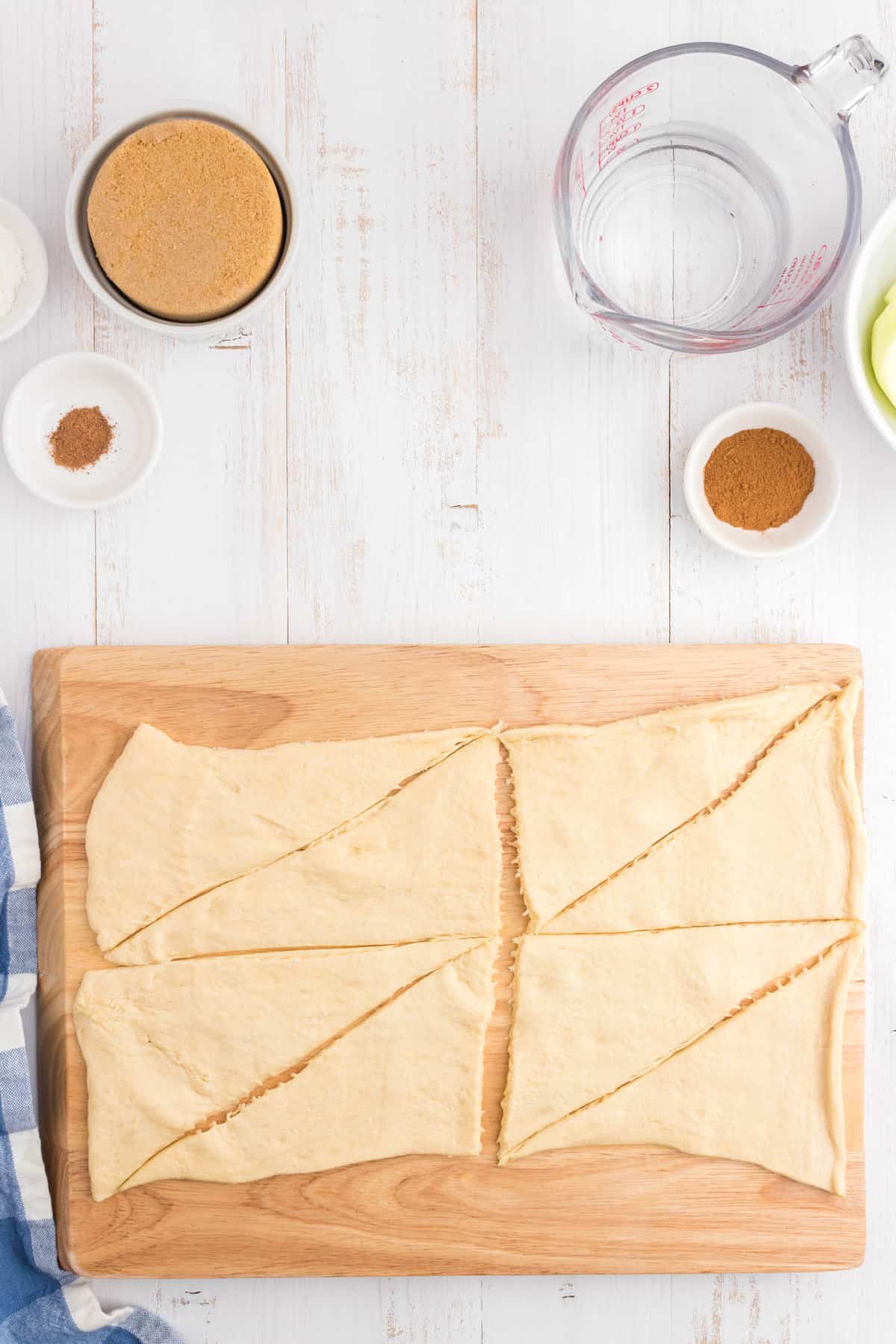 Rolling out Crescent Rolls on wooden cutting board for Apple Dumpling recipe