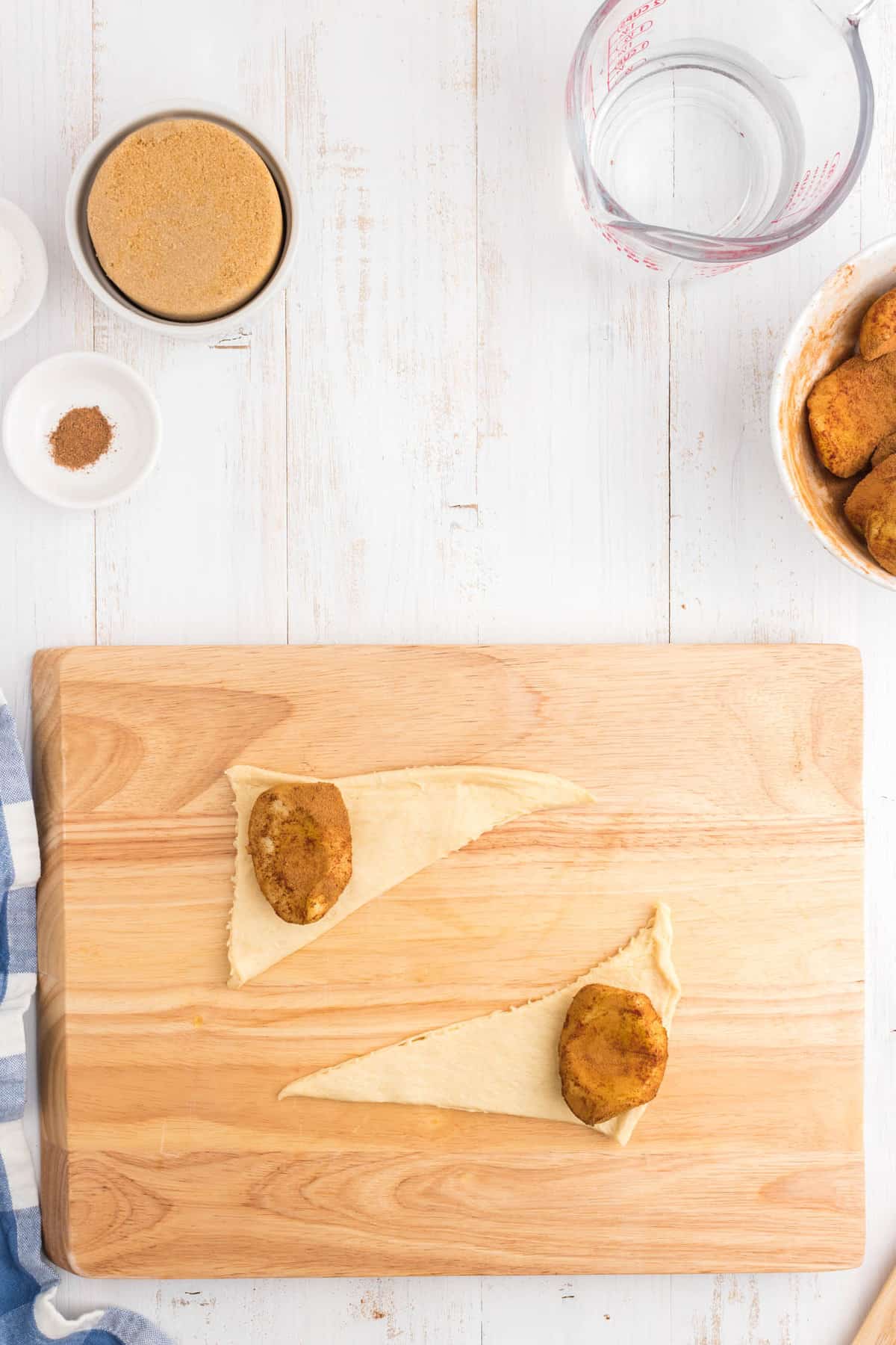 Adding cinnamon coated apples in the Crescent Rolls for Apple Dumplings