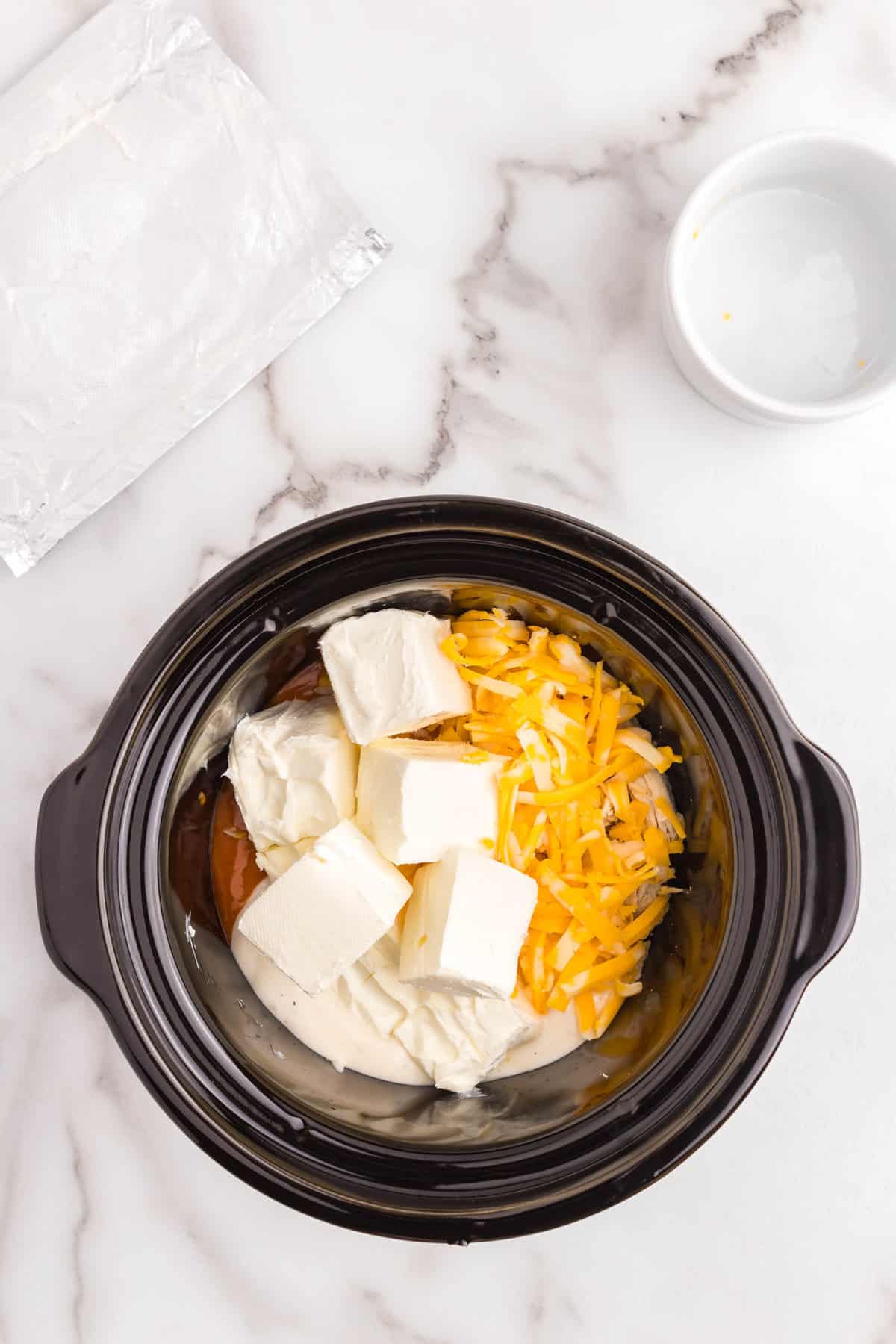 Adding cheeses to buffalo chicken mixture in crock pot