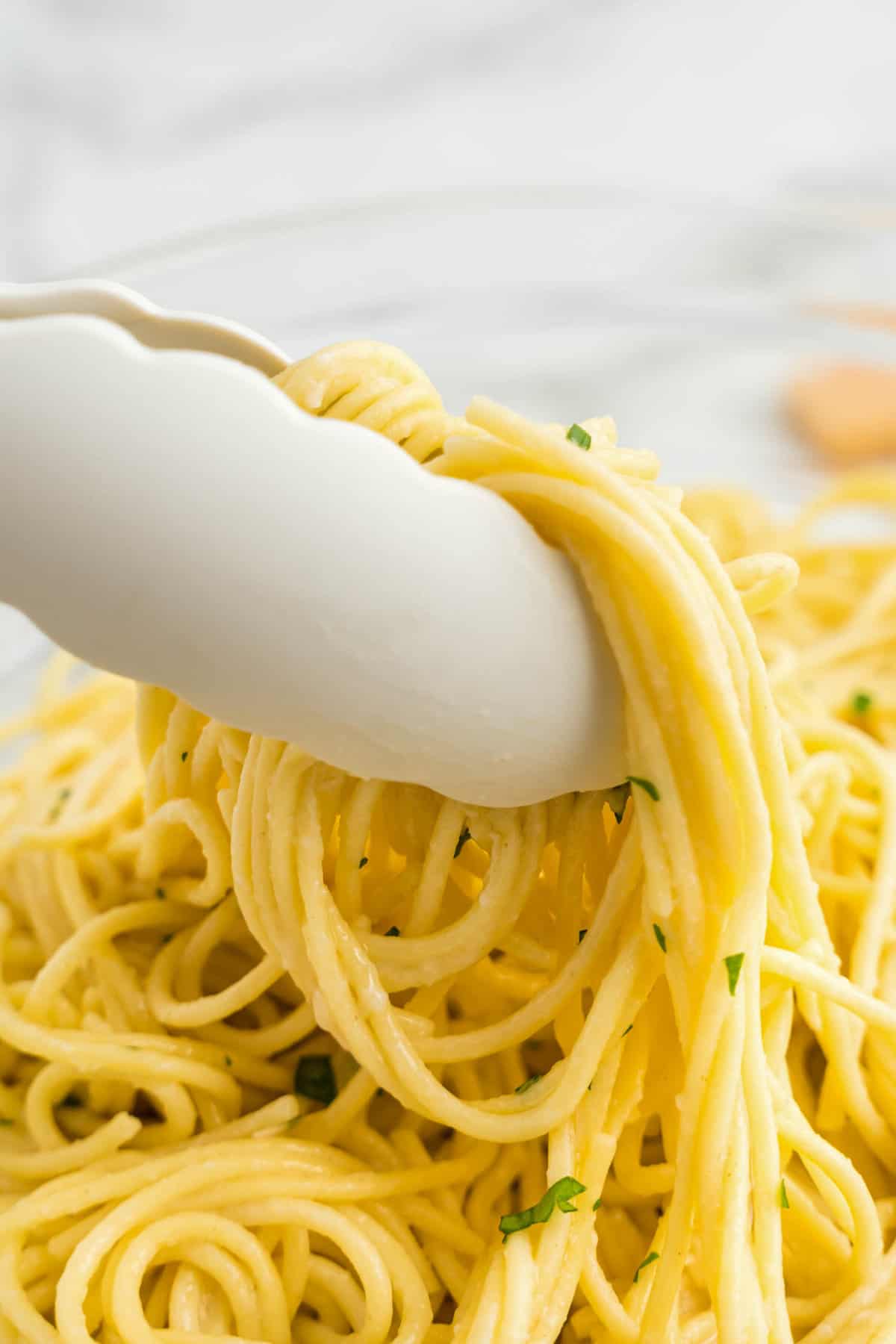 a Tongs serving buttered noodles.