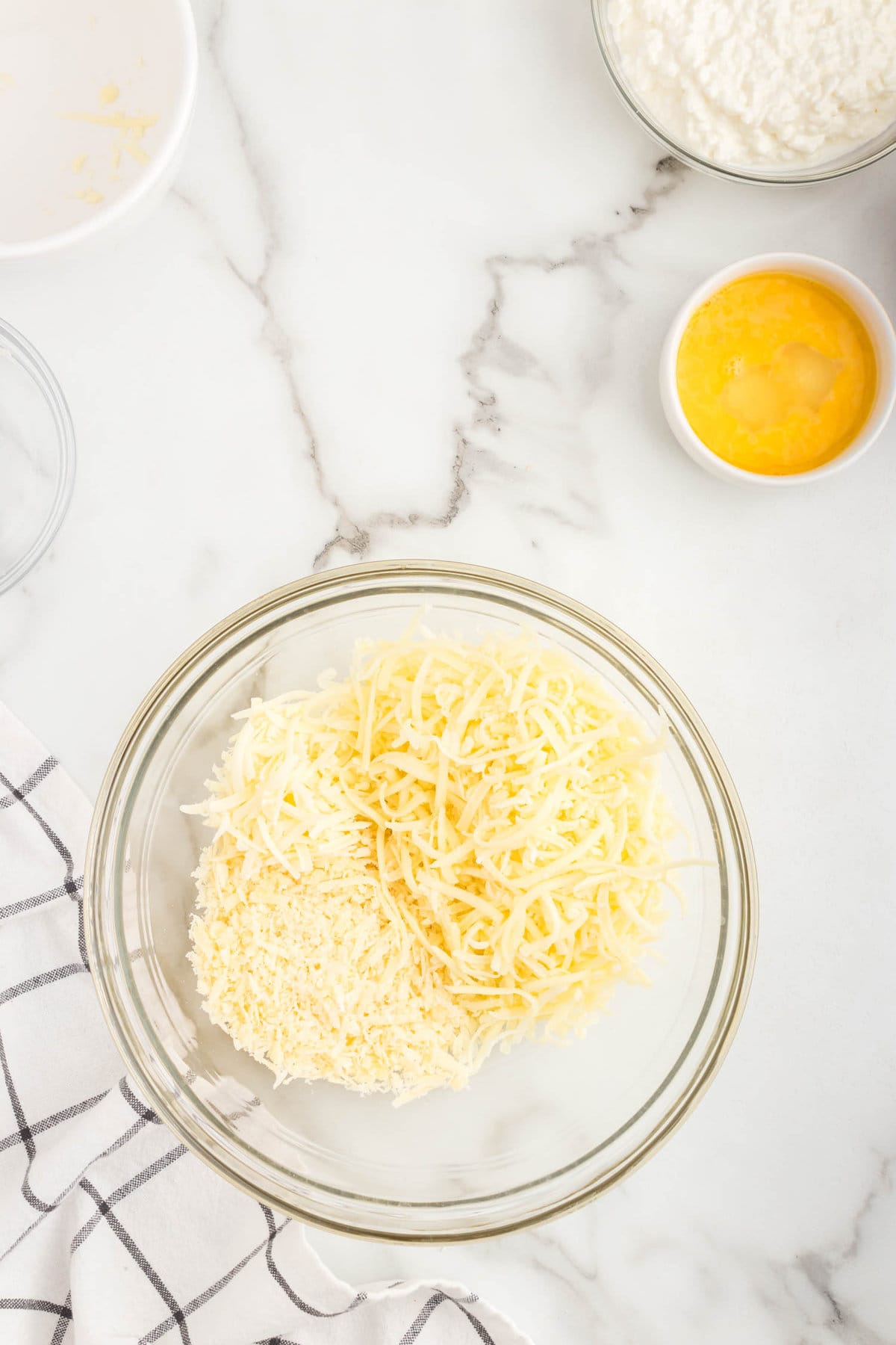 Mixing Chicken Alfredo Stuffed Shells cheeses in mixing bowl