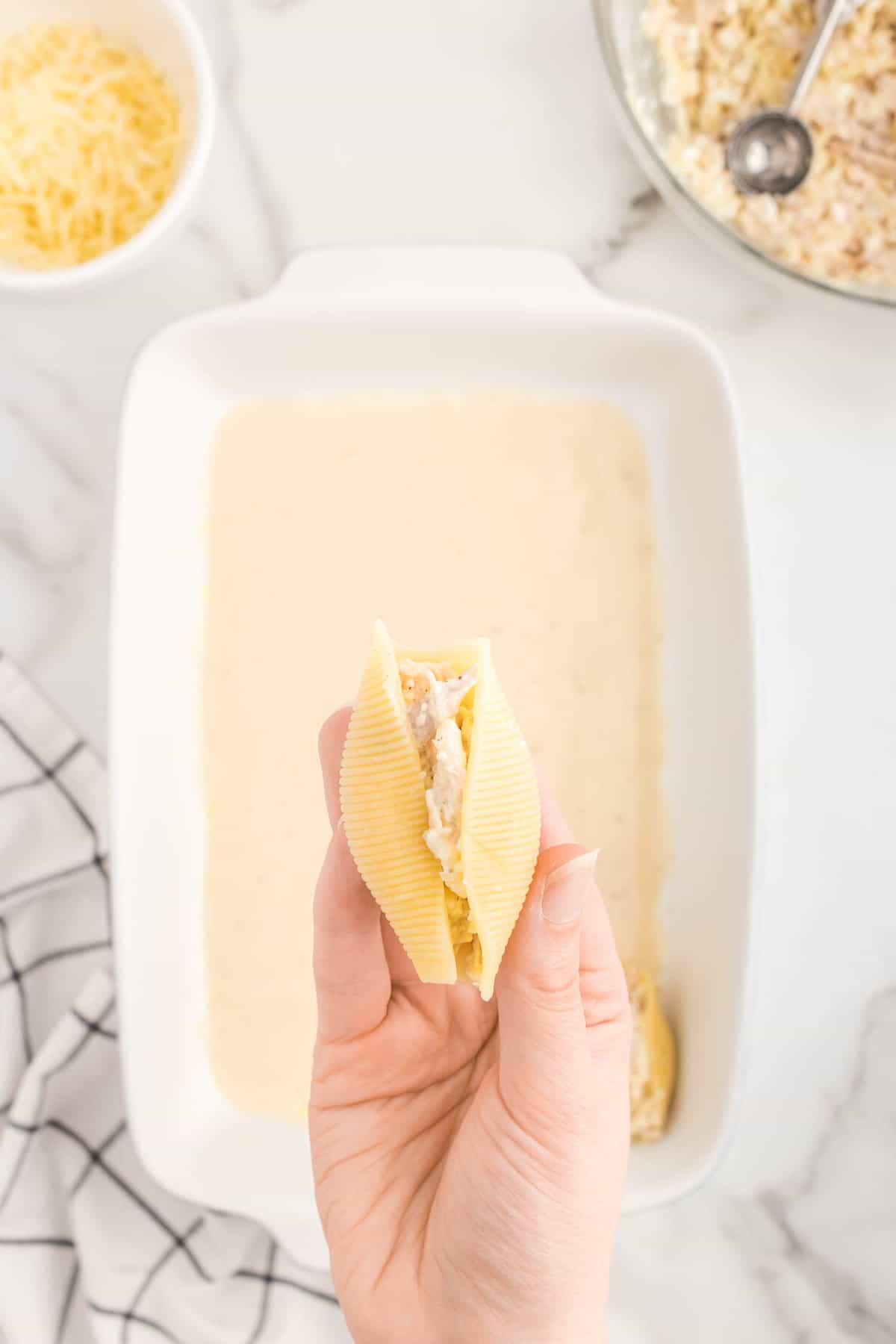 Filling jumbo pasta shells with chicken alfredo mixture for Alfredo Stuffed Shells recipe