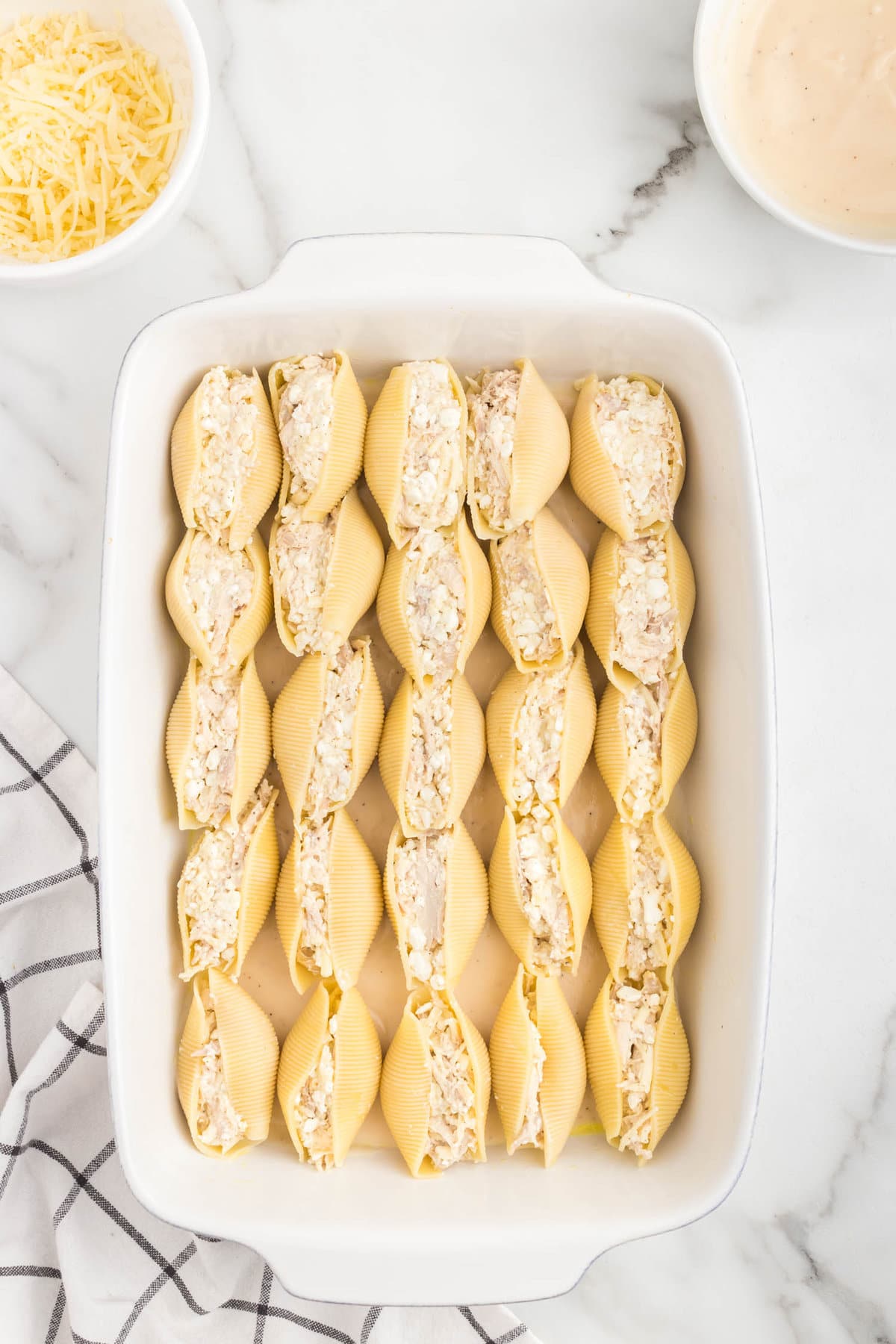 Lining stuffed pasta shells in baking dish for Alfredo Stuffed Shells recipe