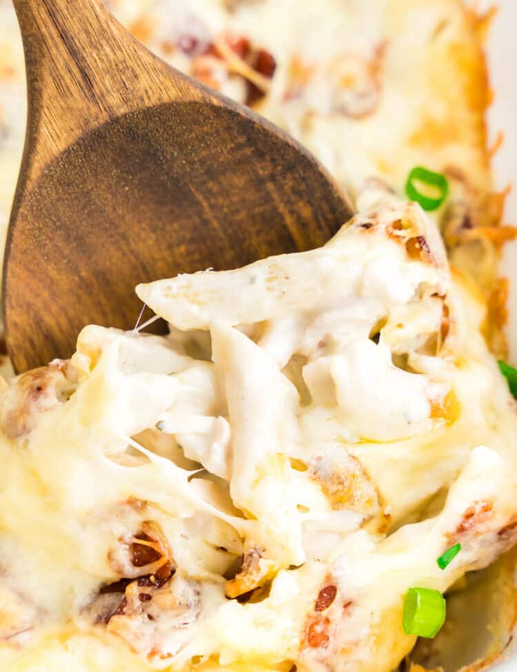 Chicken Bacon Ranch Pasta Bake in Baking Dish with Wooden Spoon Scooping