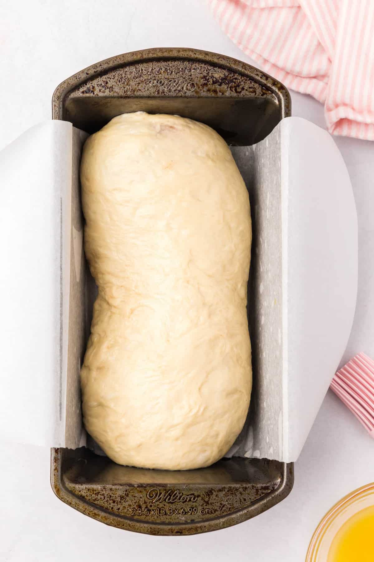 Rolled up dough, tucking in the sides. Place the bread in the prepared bread pan for Cinnamon Swirl Bread