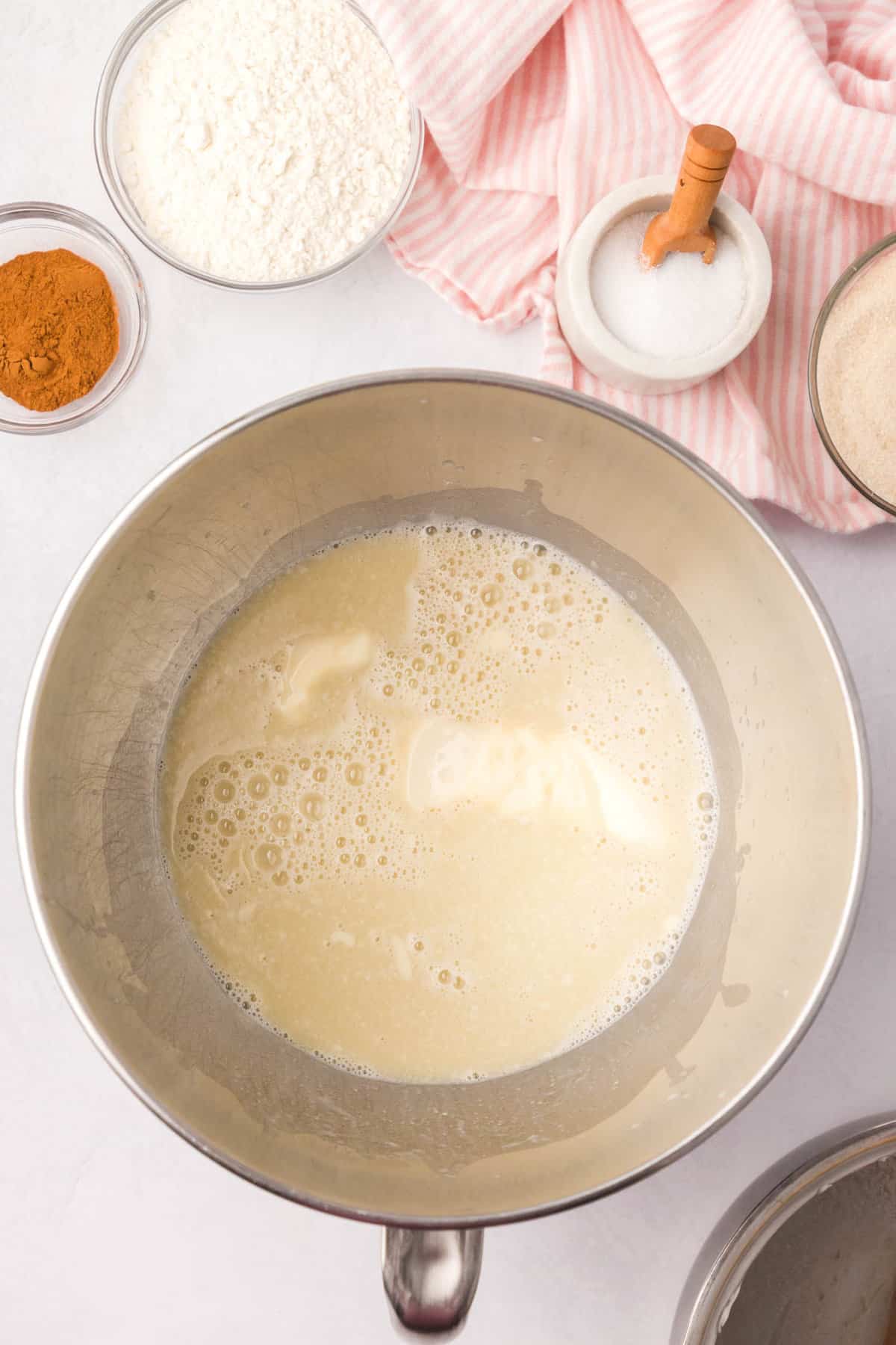 Combining warm yeast and milk mixtures for Cinnamon Swirl Bread recipe in bowl