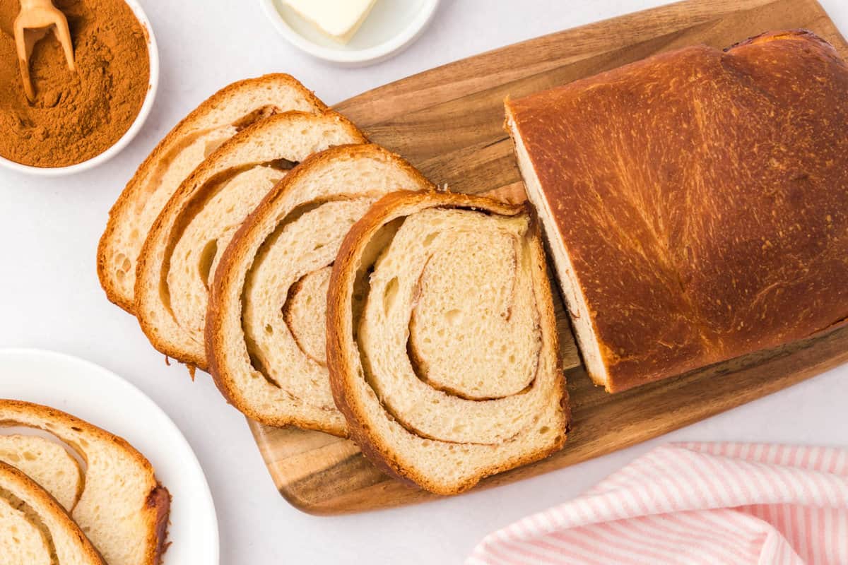 Cinnamon Swirl Bread sliced on wooden cutting board