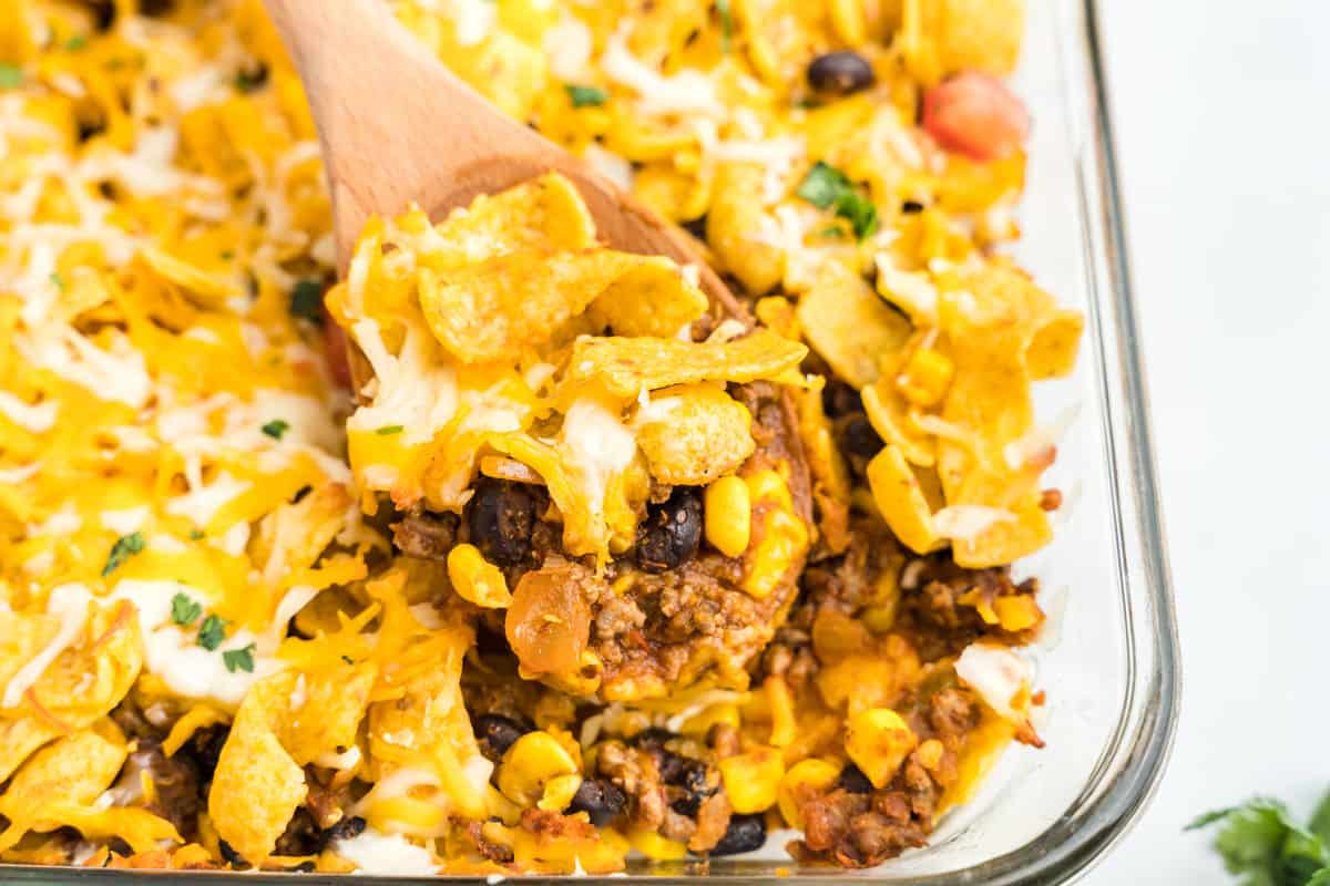Frito Pie Casserole in Baking Dish with Wooden Spoon