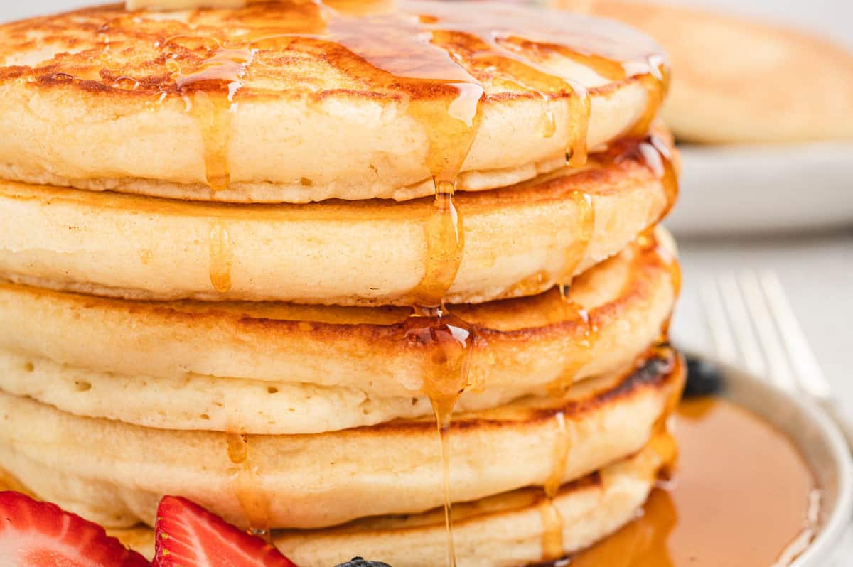 Homemade Pancakes stacked on plate with butter and syrup