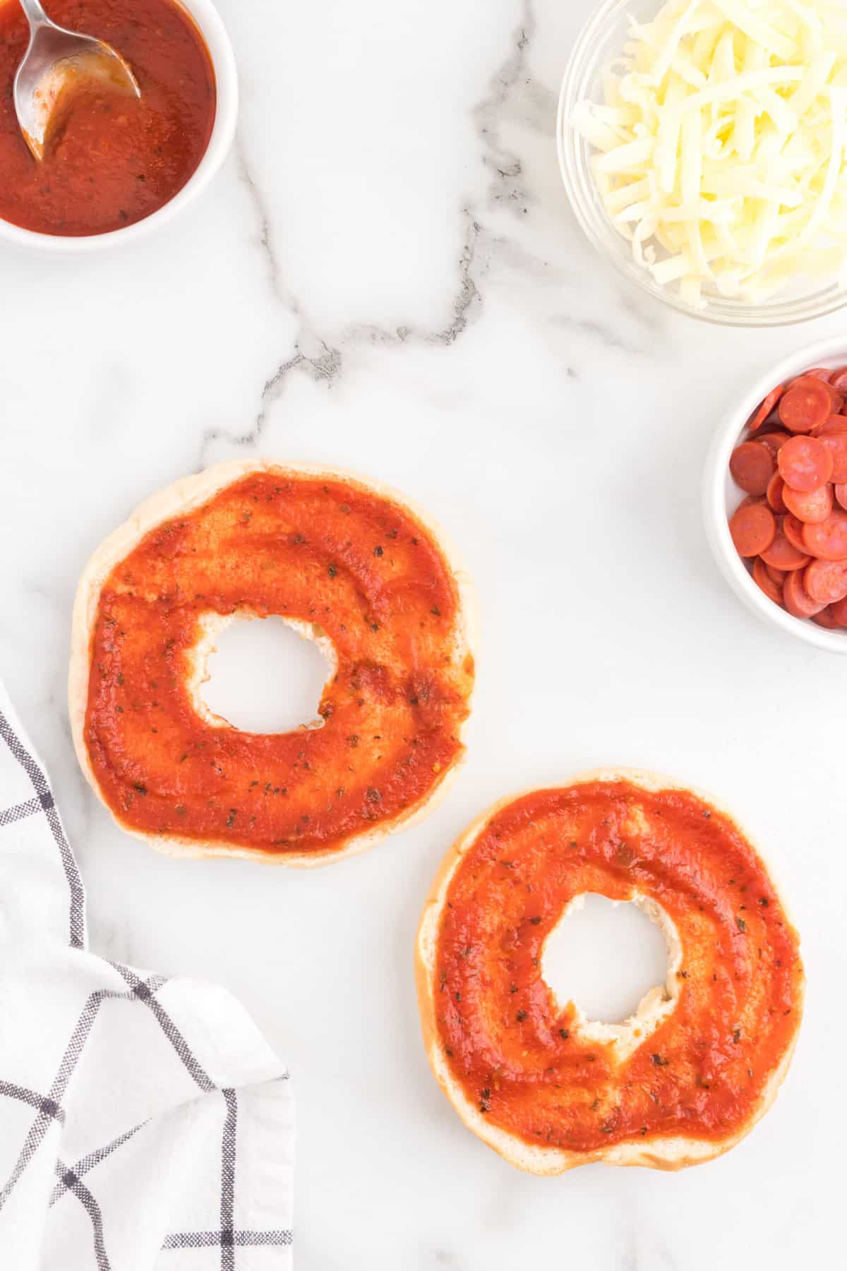 Spread Pizza Sauce onto the Plain Bagel.