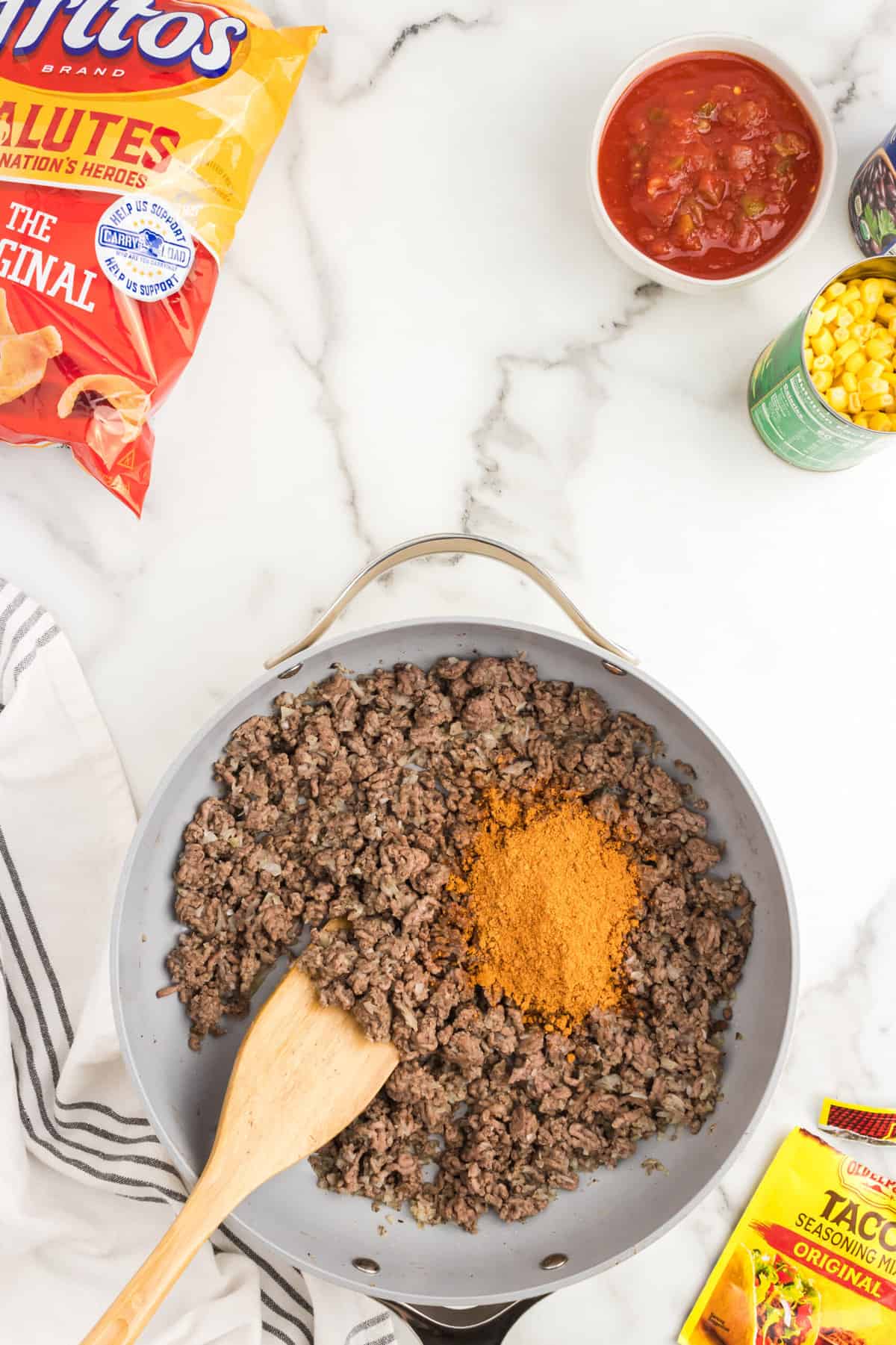 Ground beef and taco seasoning in stovetop skillet for Frito Pie Casserole