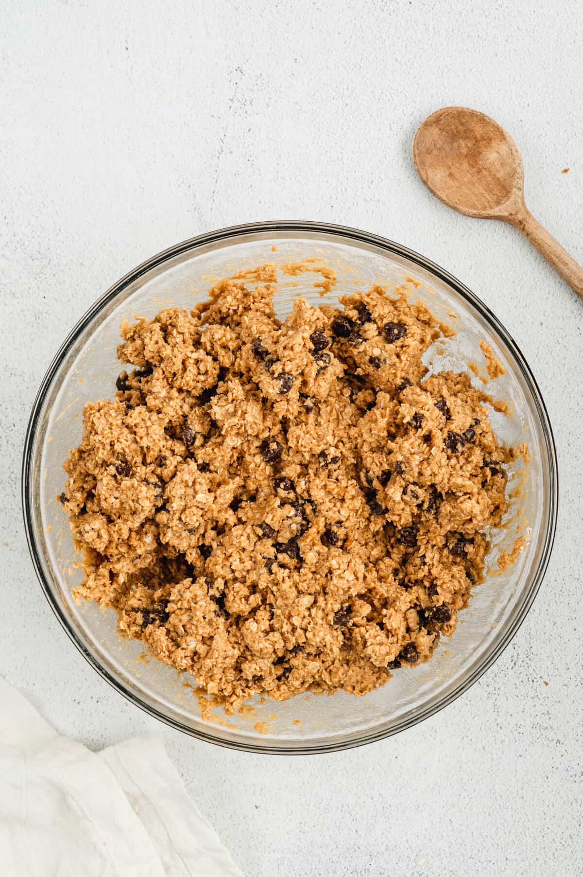 Combine Monster Cookie Bars ingredients in bowl using wooden spoon