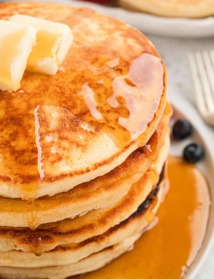 Homemade Pancakes stacked on plate with butter and syrup