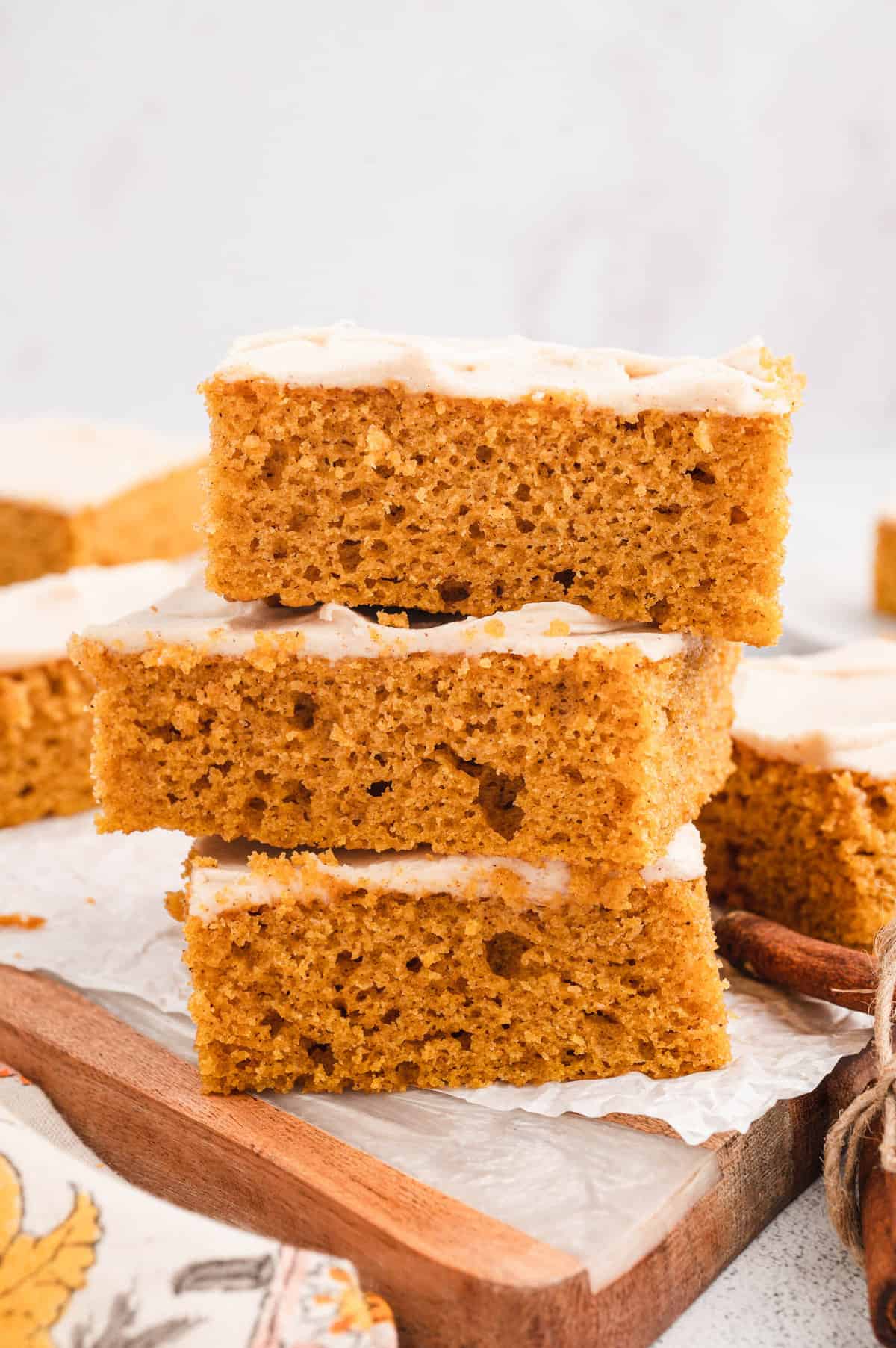 Pumpkin Bars with Cream Cheese Frosting Cut and Stacked on Serving Dish