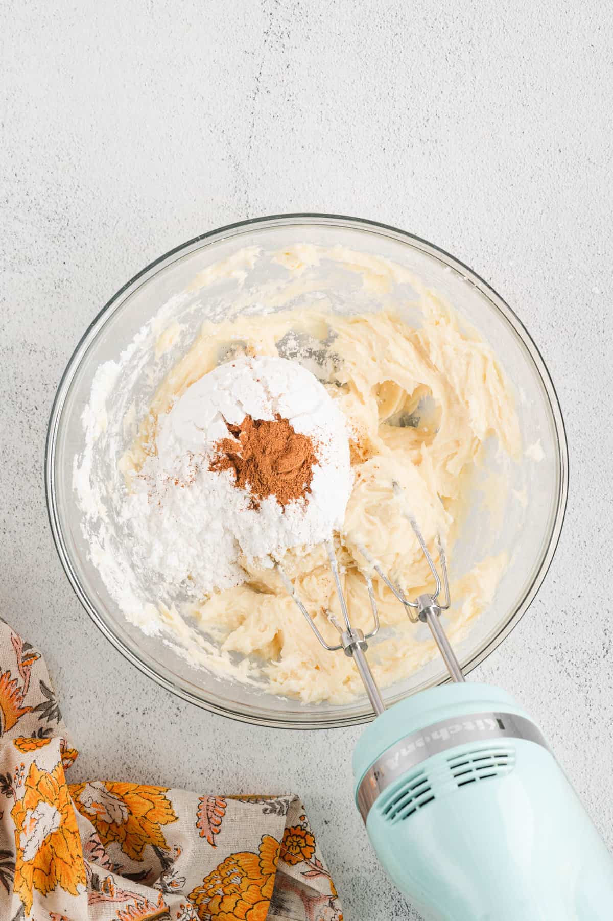Adding dry ingredients to cream chese frosting mixture for Pumpkin Bars recipe