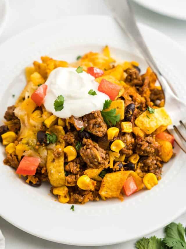 Adding sour cream, green onion, and tomato for an additional flavor burst to Frito Pie Casserole