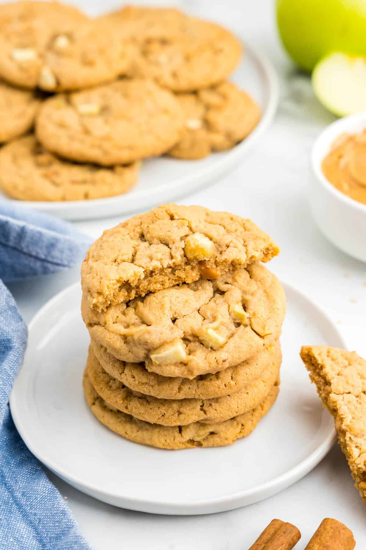 Apple and Peanut Butter Cookies stacked on plate with one cookie broken in half