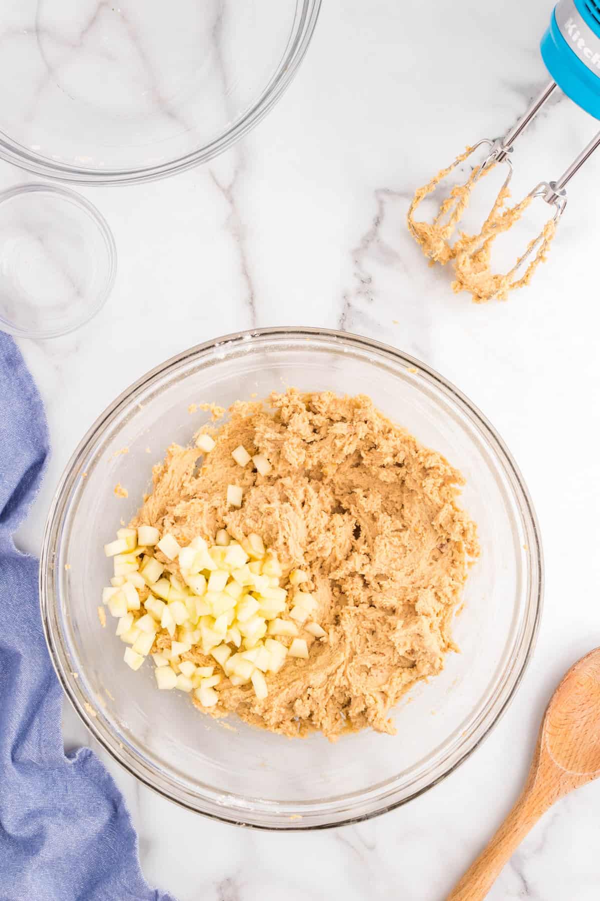 Folding in diced apple pieces into cookie dough for Peanut Butter and Apple Cookies